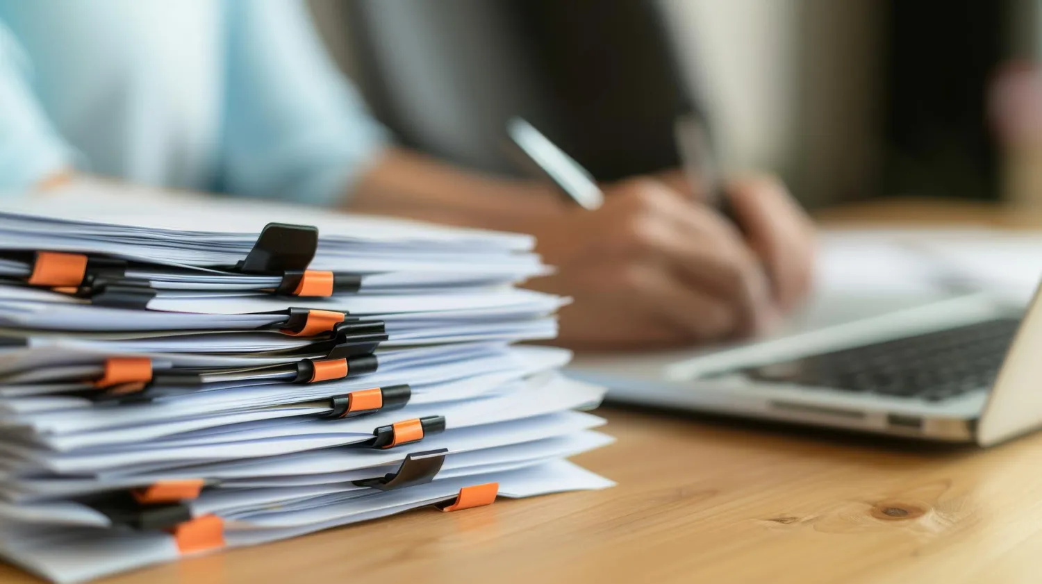 the image captures a desk with documents graphs and a laptop indicating a professional working environment focusing on paperwork analysis and business planning